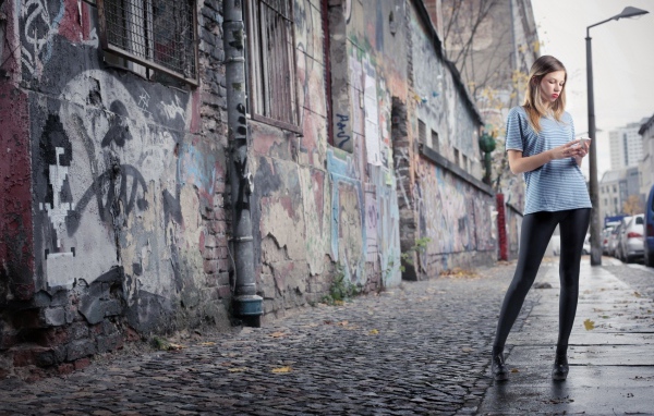 Молодая девушка стоит на улице в трущобах