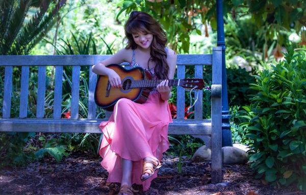 Девушка в розовом платье с гитарой