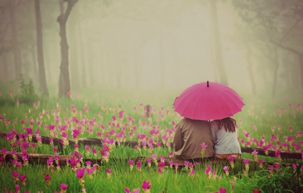 Двое сидят под зонтом