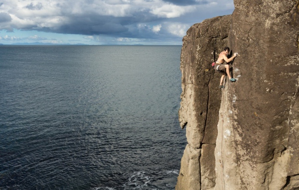 Мужчина скалолаз на скале над морем