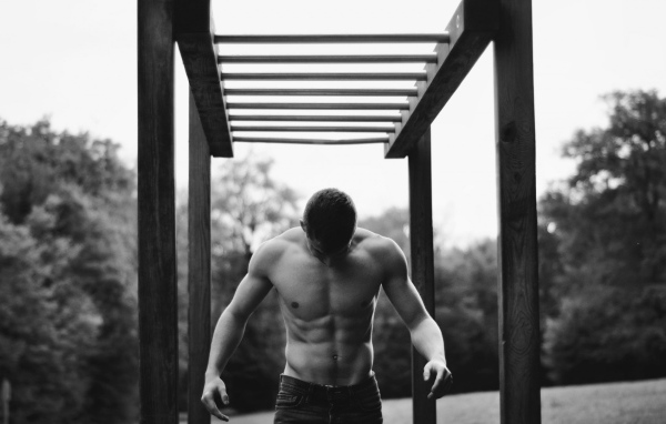 Мужчина занимается спортом на турнике