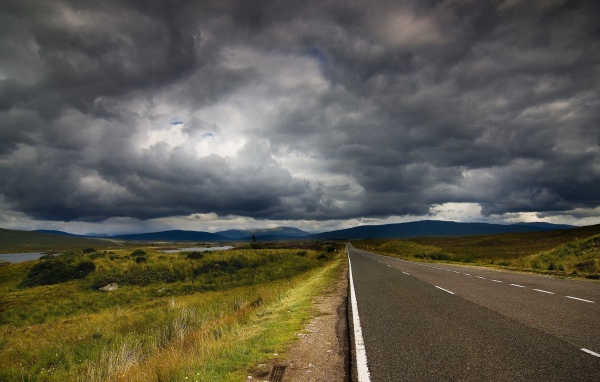 Шоссе среди полей под мрачными облаками