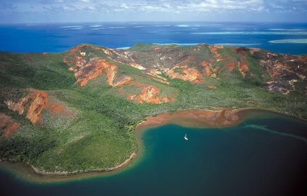 Белая лодка у необитаемого лесистого острова