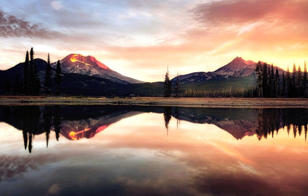 Две горы отражаются в воде озера