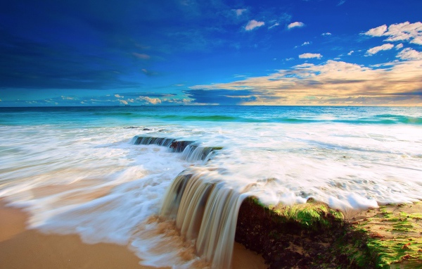 Волна прибоя накатывает на прибрежные камни