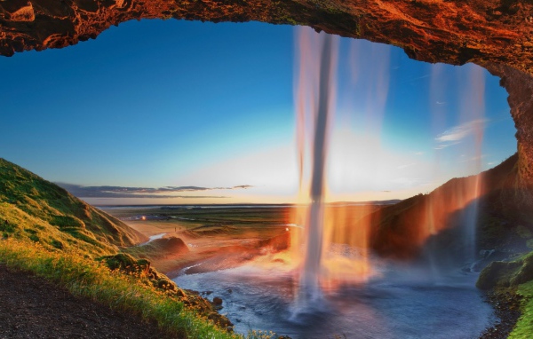 Поток воды падает с желтой скалы