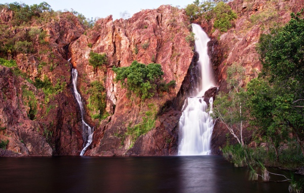 Зелень на розовых скалах с водопадом