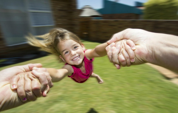 Веселая девочка в руках отца