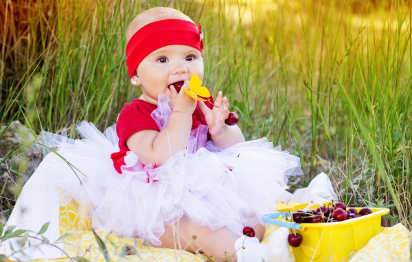 Девочка кушает спелые вишни