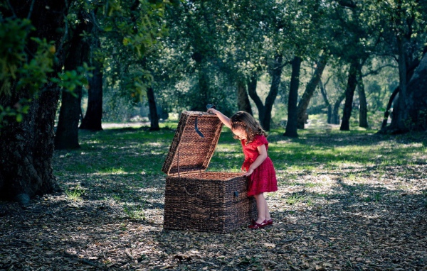 Девочка заглядывает в плетеную корзину