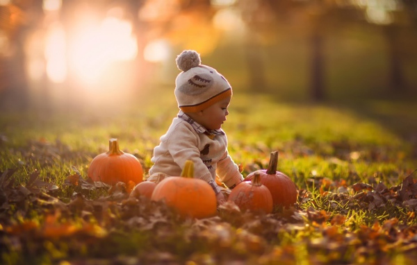 Девочка играет с тыквами