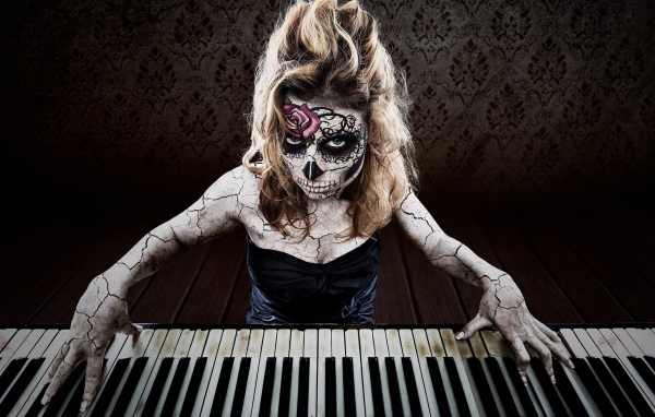 Татуированная девушка играет на пианино