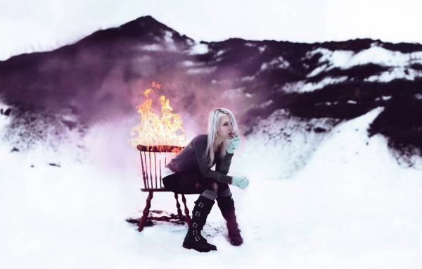 Девушка сидит на горящем стуле