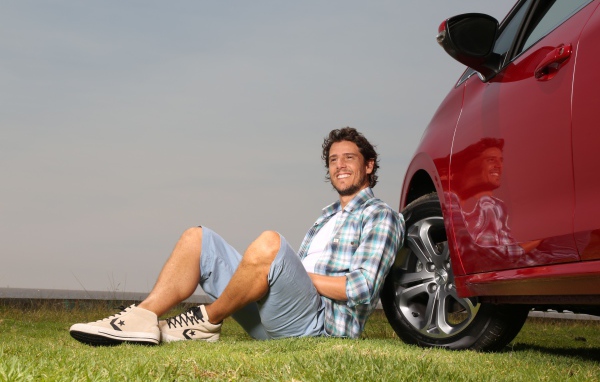 Мужчина сидит у колеса своего автомобиля