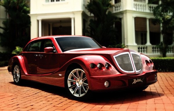 Красный роскошный автомобиль на мощеной дорожке