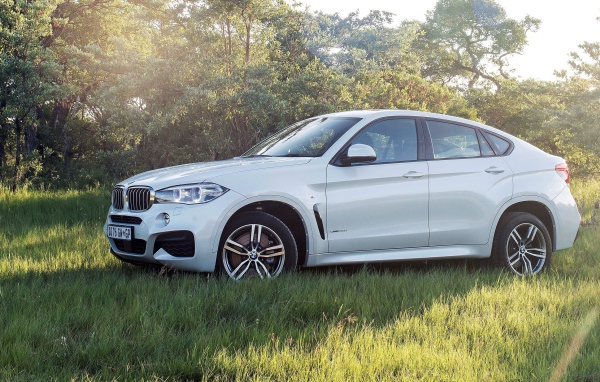 Полноприводный белый BMW на траве