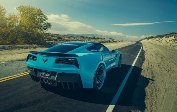 Голубой спортивный Chevrolet на шоссе в жаркой пустыне