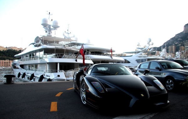 Черный Ferrari на фоне белой яхты