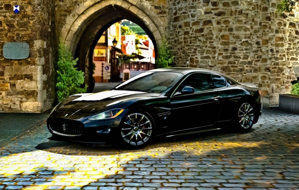 Черный Maserati gran turismo у каменной арки