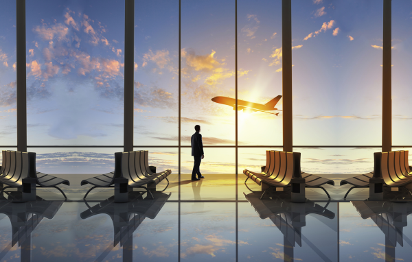 Мужчина смотрит в окно на взлетающий самолет