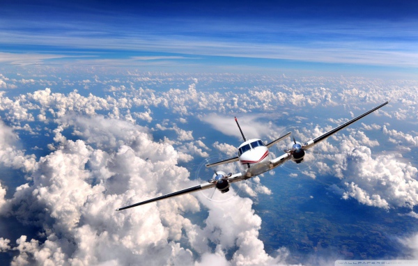 Частный самолет летит над облаками