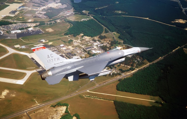 Истребитель F-16 выполняет маневр над землей