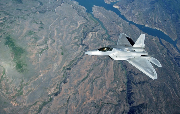 Самолет F-22 Raptor над поверхностью земли