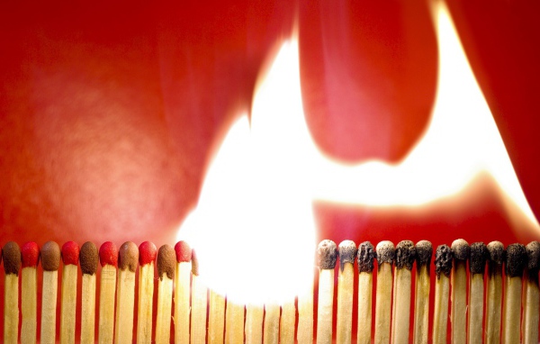 Горящий ряд спичек на красном фоне