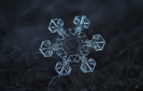 Снежинка под увеличением на черном фоне
