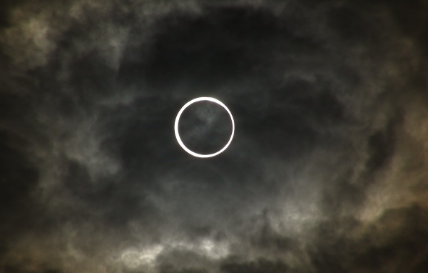 Белый круг на фоне темных облаков