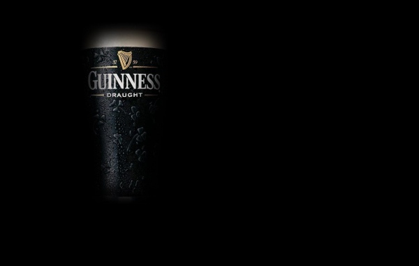 Темное пиво Guinness на темном фоне
