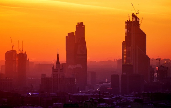 Стройка небоскребов на фоне оранжевого неба