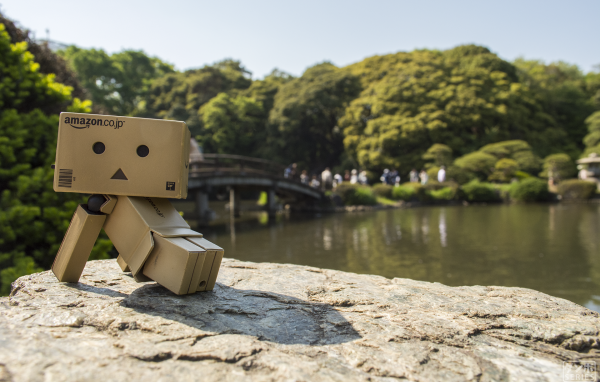 Картонный человечек на камне в саду