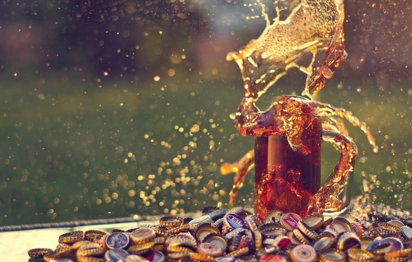 Бокал пива среди горы крышек от пивных бутылок