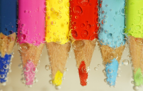 Карандаши в воде среди пузырей воздуха