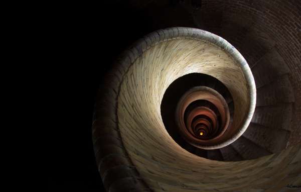 Спираль винтовой лестницы уходит вглубь