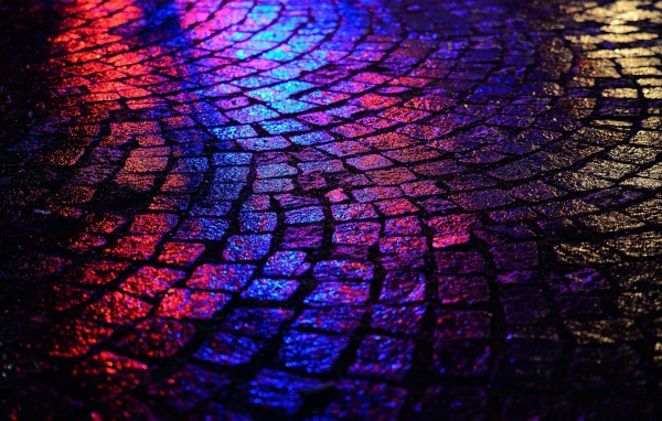 Блики ночных огней на брусчатке улицы