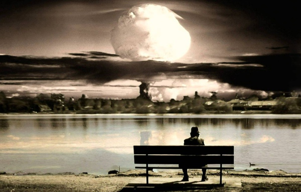 Человек смотрит на ядерный взрыв сидя на скамье