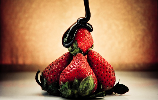 Шоколад льется на клубнику