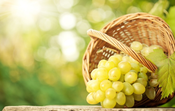 Белый виноград в плетеной корзинке