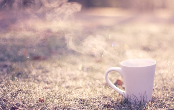 Дымящаяся чашка на траве