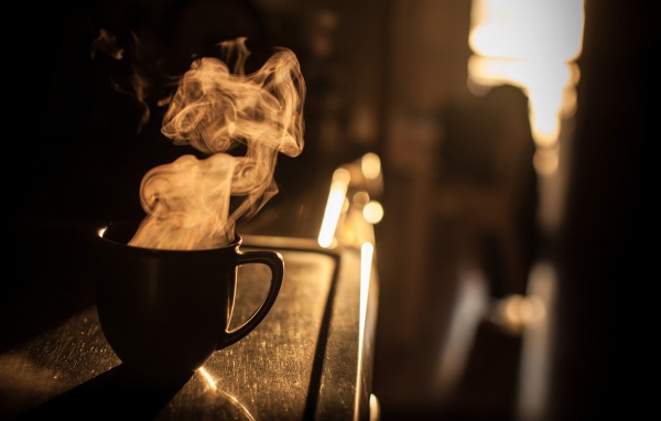 Пар из чашки кофе на закате