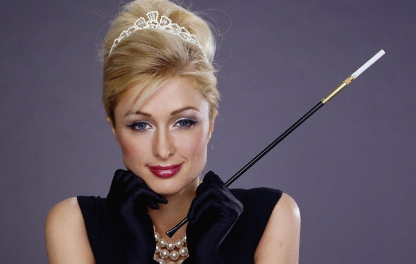 Девушка держит в руке дамский мундштук