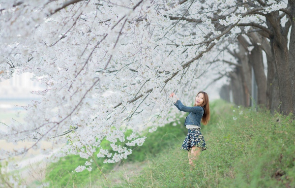 Азиатская девушка радуется весенним цветам