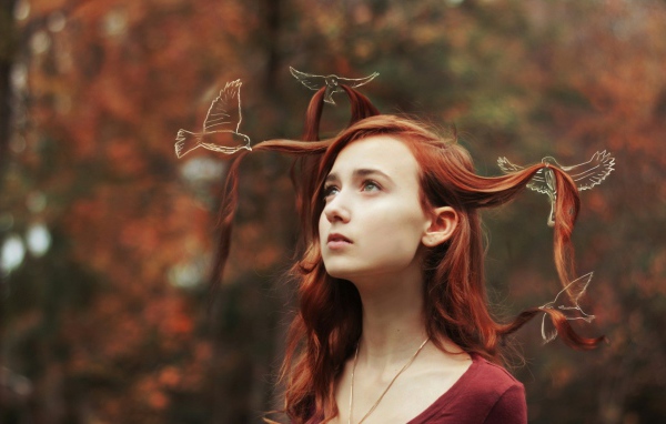 Птицы играют прядями волос у девушки