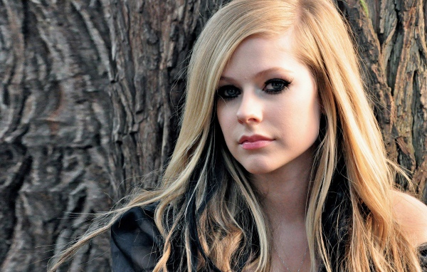 Блондинка Аврил Лавин на фоне коры дерева