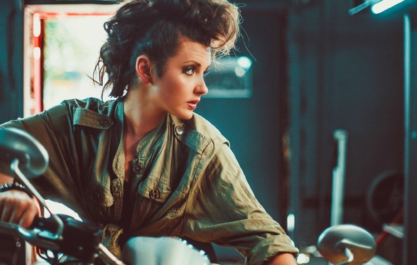 Брюнетка с высокой прической на мотоцикле