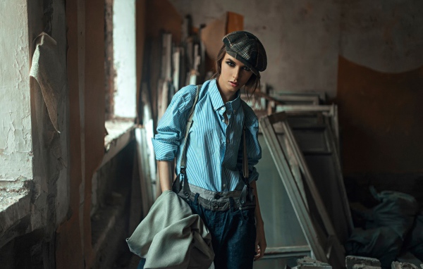 Девушка в берете стоит среди ремонта