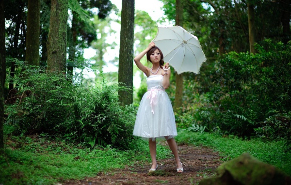 Девушка в белым зонтом в лесу