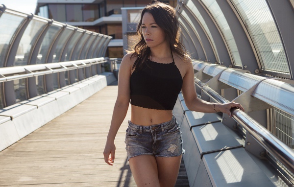 Девушка в джинсовых шортах на мосту